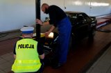 policjant wraz z diagnostą ustawiają światła w pojeździe