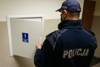 policjant otwiera skrzynkę prądową