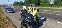 Policjanci kontrolujący na jezdni motocyklistę