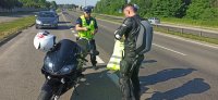 policjant wręczający kamizelkę odblaskową motocykliście