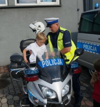 policjant pokazujący motocykl dziecku