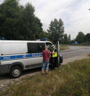 policjant kontrolujący osobę przy radiowozie