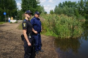 Policjant i strażnik miejski przy stawie