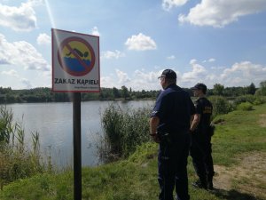 policjant i strażnik miejski nad stawem