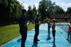 policjanci rozmawiają z chłopcami na basenie
