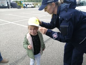 policjantka zakłada czapeczkę odblaskową dziewczynce