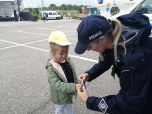 policjantka zakłada na rączkę dziewczynki opaskę