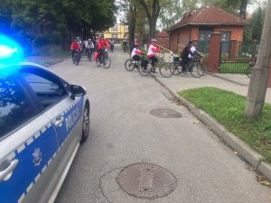 policjanci w radiowozie zabezpieczają przejazd rowerów