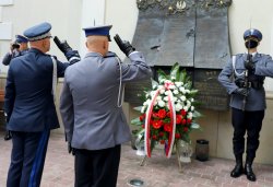 Policjanci salutują przed pomnikiem