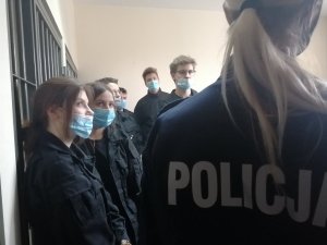 policjantka opowiada młodzieży o pomieszczeniu dla osób zatrzymanych