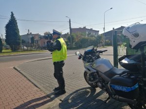 policjant drogówki przy motocyklu z miernikiem prędkości