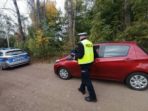 policjant ruchu drogowego kontroluje pojazd