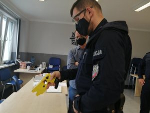 policjant sprawdza taser