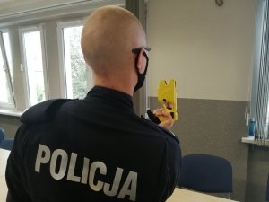 policjant sprawdza działanie tasera