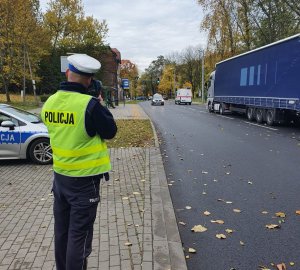 Policjant ruchu drogowego dokonuje pomiaru prędkości na drodze