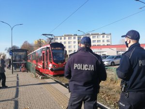 Policjanci czekają na nadjeżdżający tramwaj