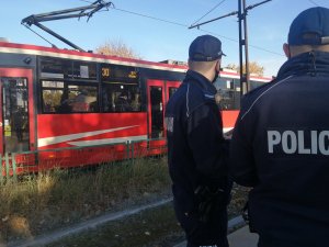 Przejeżdża tramwaj obok stoją policjanci