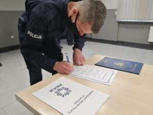 Policjant składa podpis na ślubowaniu