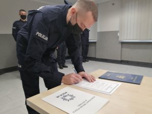 Nowo przyjęty policjant składa podpis