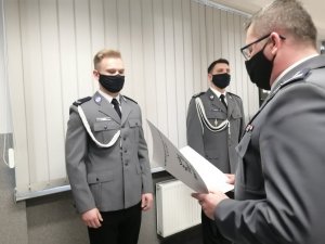 Komendant wręcza rozkaz policjantowi