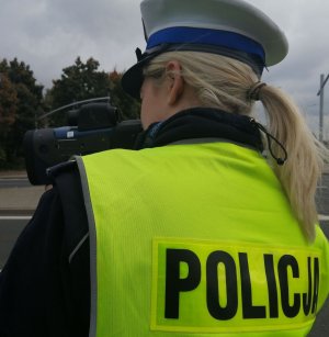 Policjantka dokonuje pomiaru prędkości na drodze