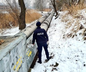 Policjant sprawdza rejon przy rurach ciepłowniczych