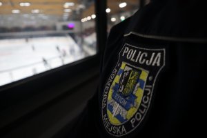 Emblemat Policji i widok na taflę lodowiska