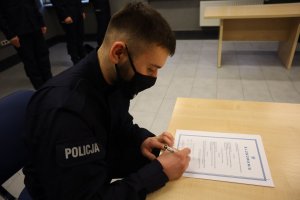Podpisuje rotę ślubowania nowy policjant