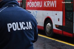 Policjant przed autokarem do oddawania krwi