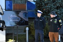 Policjant i kierowca rajdowy przed kamerą prezentują spot