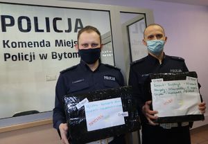 Policjanci w mundurach z paczkami w bytomskiej komendzie