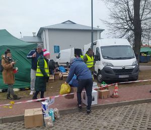 Ludzie pomagają nosić paczki z darami w tle zaparkowany samochód