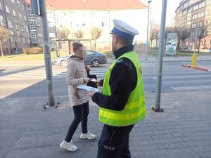 Kobieta otrzymuje ulotkę od policjanta