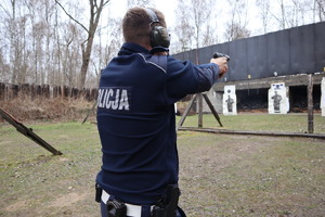 Policjant oddaje strzał w kierunku tarczy