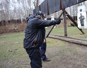 Instruktor pokazuje policjantowi sposób oddania strzału