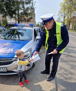 Policjant daje chłopcu odblaski