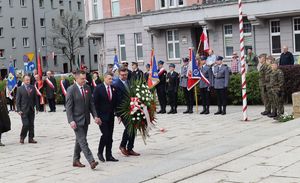 Przedstawiciele władz miasta idą złożyć kwity pod pomnikiem