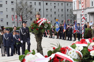 Żołnierz niesie wieniec pod pomnik