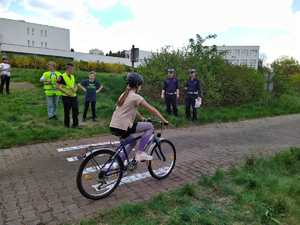 Policjanci oceniają przejazd rowerzystki w miasteczku rowerowym