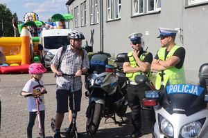 Policjanci przy motocyklu policyjnym na festynie