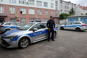 Policjant stoi przy radiowozie