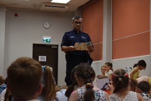 Policjant pokazuje dzieciom broszurę