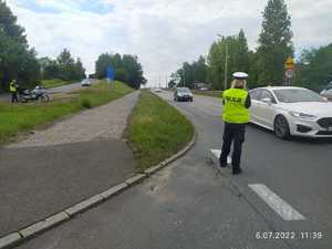 Policjantka mierzy prędkość przy drodze