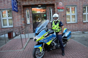 Policjant ruchu drogowego na motocyklu przed komendą