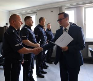 Prokurator wręcza list gratulacyjny policjantowi