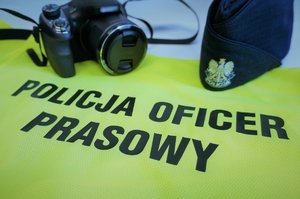 Koszulka odblaskowa z napisem oficer prasowy, aparat fotograficzny i czapka