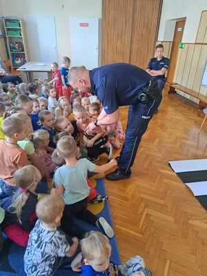 Policjant pokazuje dzieciom legitymację służbową