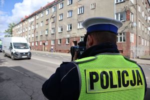 Policjant mierzy prędkość nadjeżdżającego pojazdu.