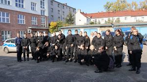 Wspólne zdjęcie na placu wewnętrznym bytomskiej komendy, policjantka i uczniowie klasy mundurowej.