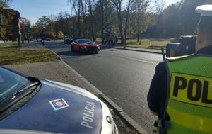 Policjant dokonuje pomiaru prędkości na drodze.